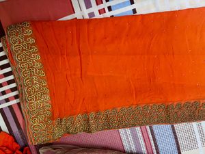 Vibrant Orange Saree with Stone Work and Ornate Em