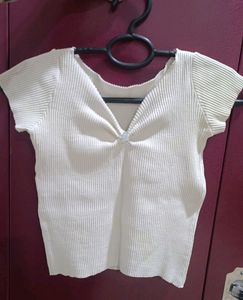 white ribbed cropped top with a charm