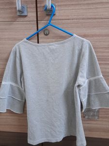 It&#39;s Black, White With a Slight Grey Shade In It. It Has a Circle Like Design, Very Comfy, Simple Yet Good Looking Top. It Is Stretchable. Pair It With A Black Jeans You Will Look Amazing.