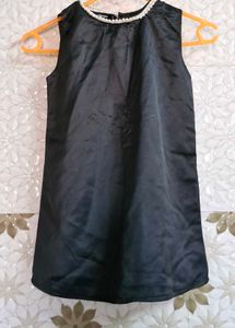Sleeveless Dress With White Trim Around A Neckline