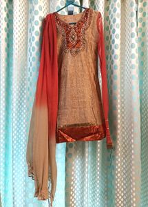Heavy Designer Party Wear Golden Silk Printed Kurti With Churidar Net Sleeves , Full Lining And Velvet Border . Heavy Zardozi Embroidery On Front . Shaded Chiffon Dupatta With Gota. No Bottom.