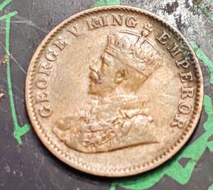 “1936” British India one-quarter Anna coin.