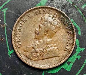 “1936” British India one-quarter Anna coin.