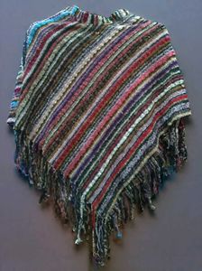 a colorful, striped poncho-style shawl with fringe
