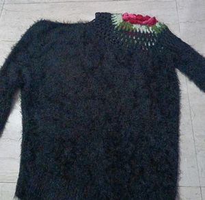 A soft sweater with flower on it.