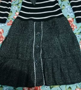 This is a black and white striped sweater dress wi