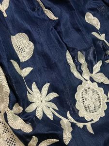 A navy blue ethenic skirt with shiny material .