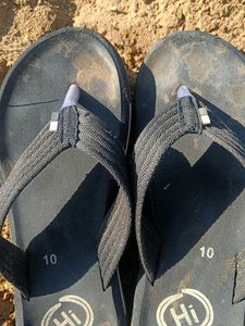Sand-covered slippers resting on the ground