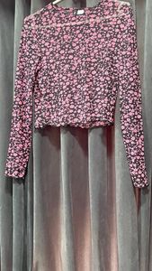 Cropped top in soft fabric with a round neckline, long sleeves and overlocked edges at the cuffs and hem.
