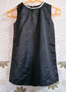 Sleeveless Dress With White Trim Around A Neckline