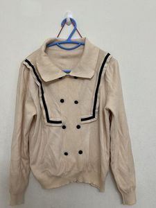 beige long-sleeved top with a sailor