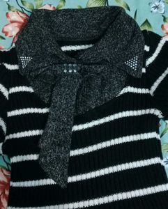 This is a black and white striped sweater dress wi