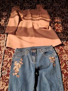 A long-sleeved pink top and embroidered blue jeans