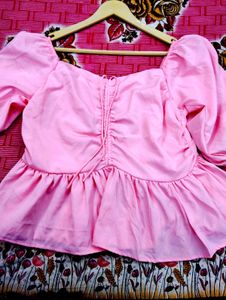 pink puff-sleeve peplum top with a ruched front an