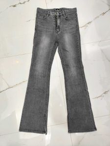 A lightly washed charcoal grey boot cut jeans