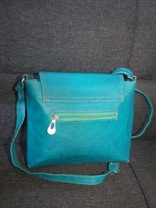 BLUE SLING BAG WITH ADJUSTABLE STRAP.