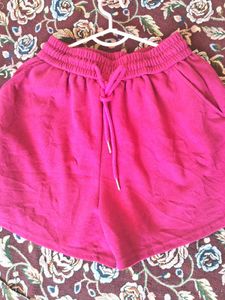 A pair of fuchsia shorts with  drawstring waist