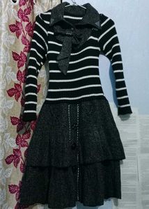 This is a black and white striped sweater dress wi