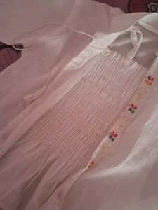 Its A White Top Wear With Multicolor Embroidery