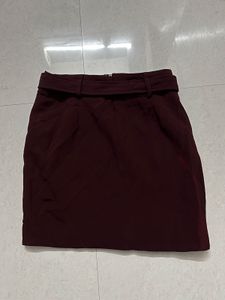 burgundy ruffled mini skirt with a belt.