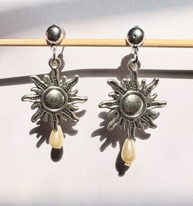 Metal sun with a pearl drop earring