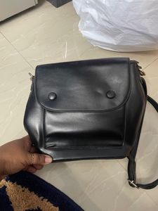 Black Sling Bag From Ajio. This Sling Is Sturdy and Useful For Keeping A Small Purse Along With Two Phones And Other Small Items. Bag Has 5 Compartments.