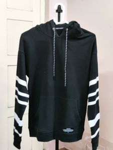 black hooded sweatshirt with white stripes on the sleeves.