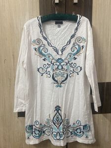 Blue Embroidery On A White Tunic
