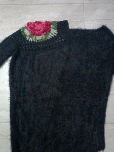 A soft sweater with flower on it.
