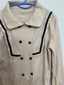 beige long-sleeved top with a sailor