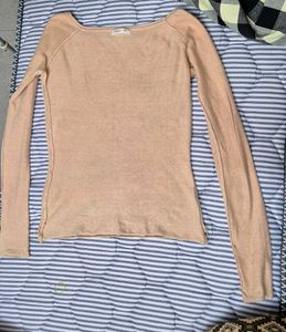 light beige or nude-colored long-sleeve top