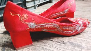 A pair of red, embroidered flat shoes..