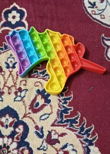 A rainbow-colored unicorn-shaped pop-it fidget toy