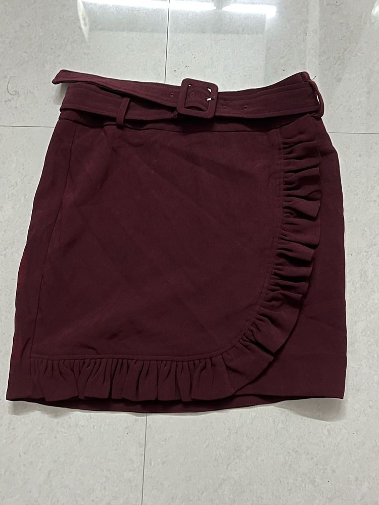 burgundy ruffled mini skirt with a belt.