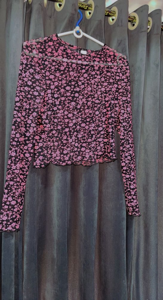 Cropped top in soft fabric with a round neckline, long sleeves and overlocked edges at the cuffs and hem.