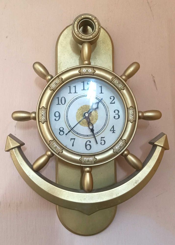 present analog wall clock with glass pendulum