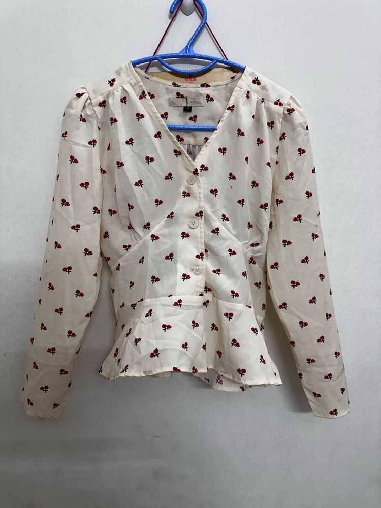 long-sleeved peplum blouse in an off-white
