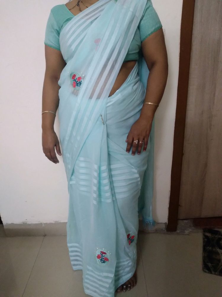 Sky Blue Saree And Blouse  With Red Colour Flower Patches On It With Little Bit Of Stone Work Very Beautiful Saree