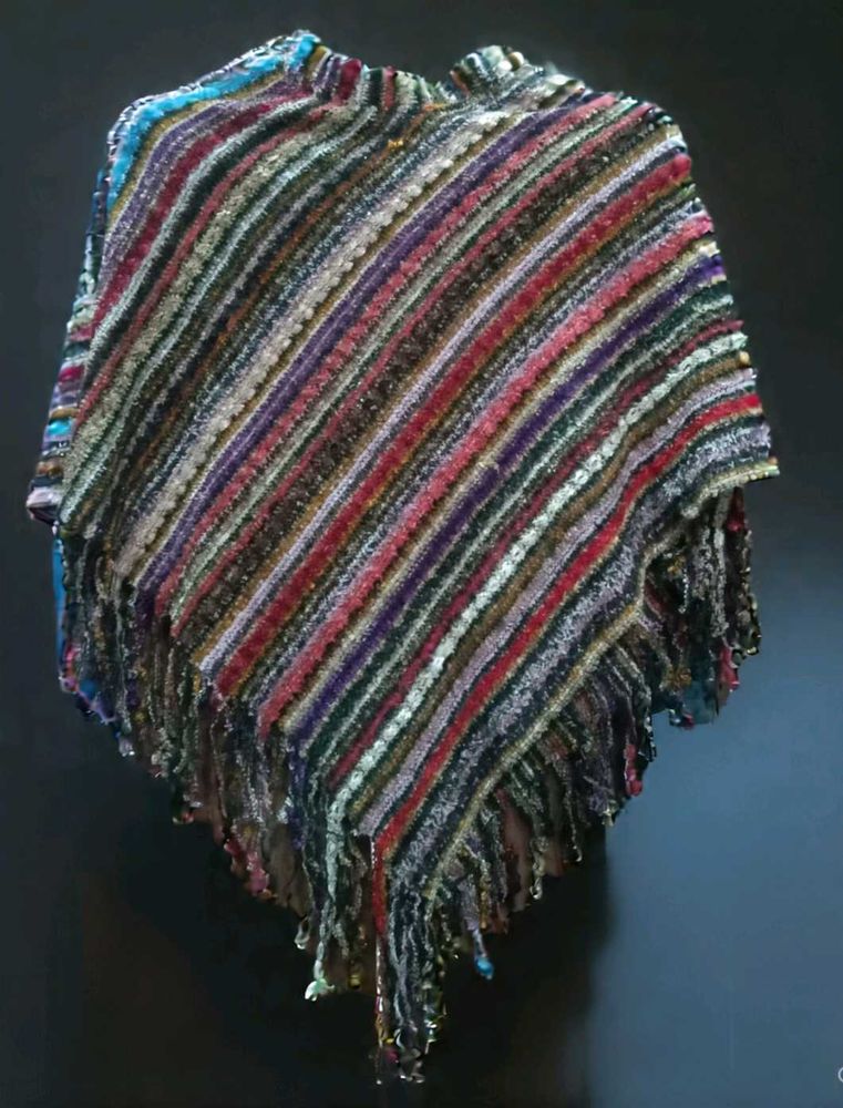 a colorful, striped poncho-style shawl with fringe