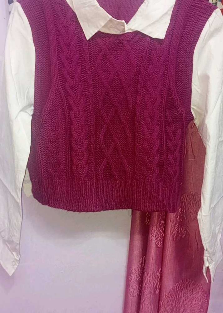 cable-knit sweater vest layered over a white colla