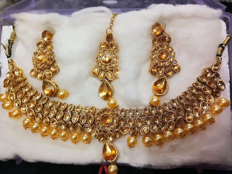A Diamond Necklace Set With Earnings And Mangtika