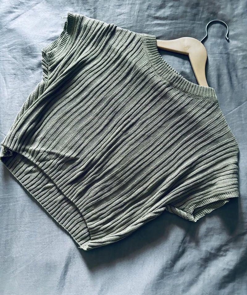 top or sweater in a muted sage green