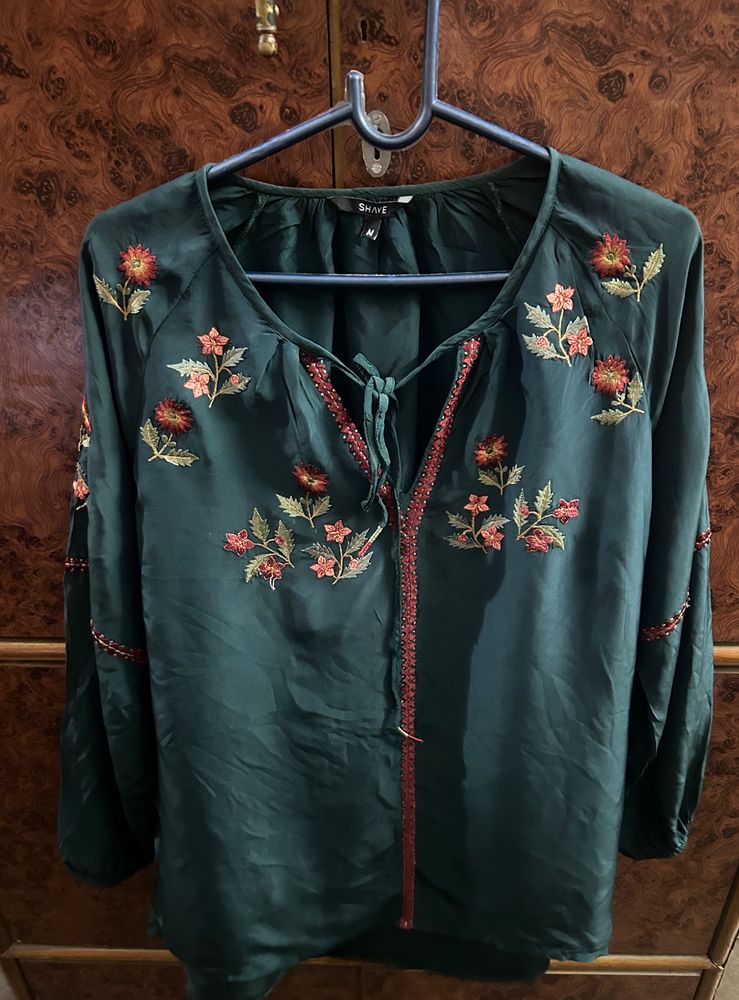 Bottle, green colour, full sleeves, top with elastic at the sleep, end and embroidery work in the front and in the arms of the top