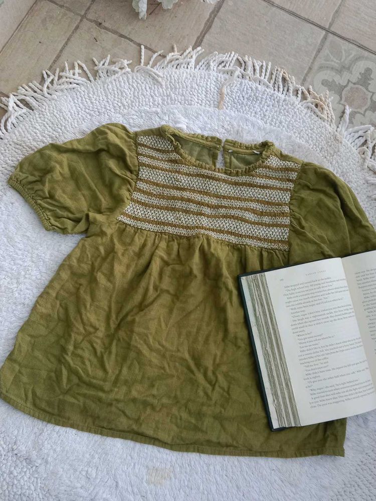 An olive-green kids&#39; top with puff sleeves