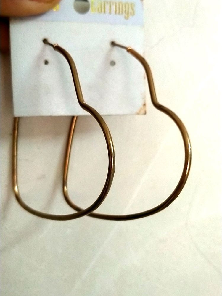 Two Heart Shaped Hoops In Gold .