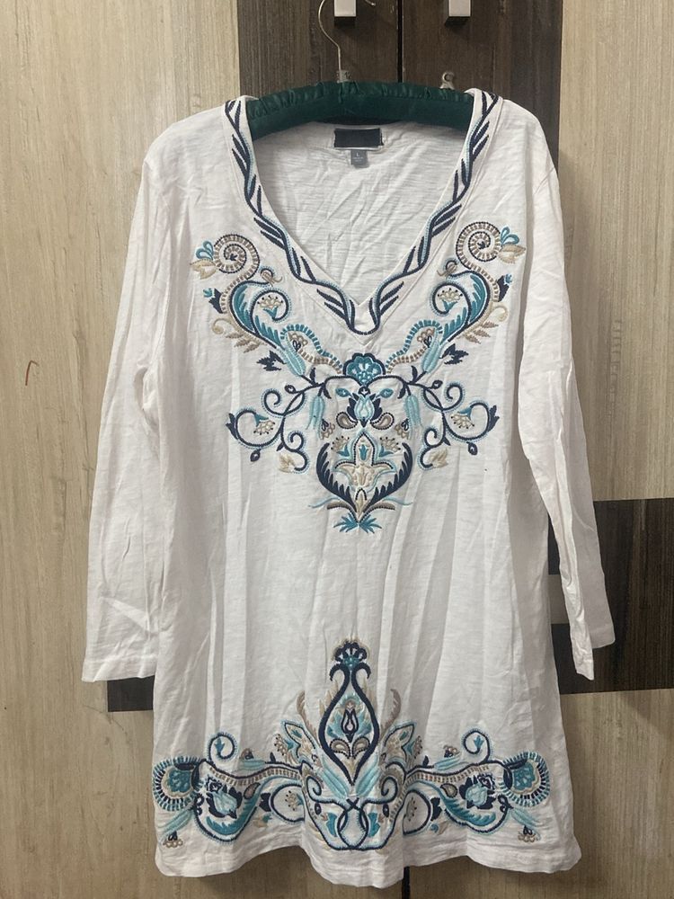 Blue Embroidery On A White Tunic