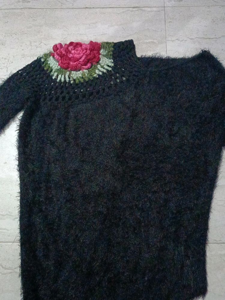A soft sweater with flower on it.